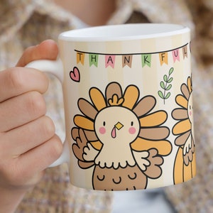May include: White ceramic mug with a Thanksgiving theme. The mug features a brown and orange turkey with a cute face and the word "THANKFUL" in a banner across the top.