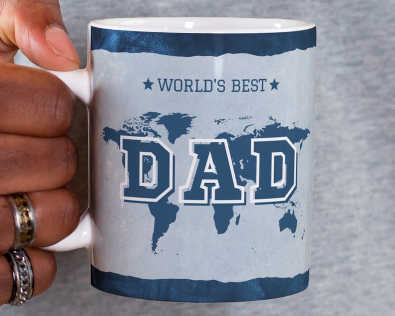 May include: White ceramic mug with a blue and white world map design. The text "WORLD'S BEST DAD" is printed on the mug.
