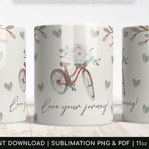 May include: White ceramic mug with a floral design and a red bicycle with a basket of flowers. The text "love your journey!" is written on the mug.