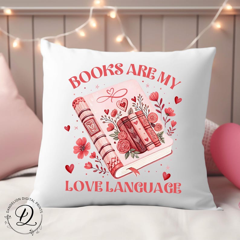 May include: White square cushion with the text "BOOKS ARE MY LOVE LANGUAGE" in red. The cushion features a pink book illustration with hearts, flowers, and other books. A decorative item for a bedroom or living room.