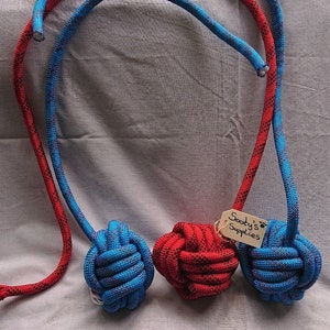 May include: Three knotted rope dog toys, one red and two blue, with a tag that reads "Sooty's Supplies".