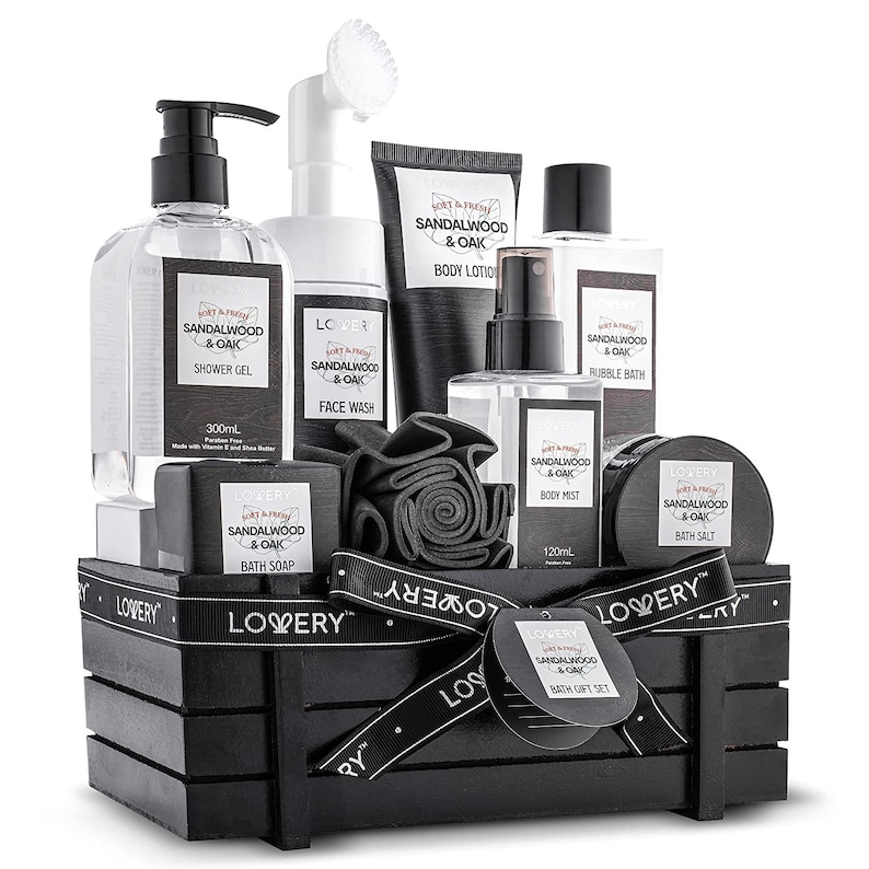 May include: A black wooden crate filled with a "Sandalwood & Oak" bath gift set. The set includes shower gel, face wash, body lotion, bubble bath, body mist, bath salt, and a bath soap. The set is tied with a black ribbon.