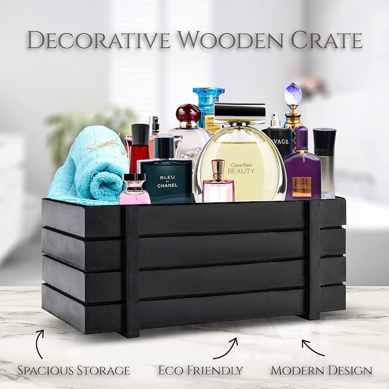 May include: A black decorative wooden crate filled with perfume bottles and a blue towel. The crate has horizontal slats and the text "DECORATIVE WOODEN CRATE". The crate is labeled "SPACIOUS STORAGE", "ECO FRIENDLY", and "MODERN DESIGN".