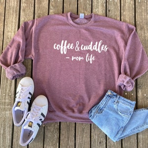 May include: A maroon sweatshirt with the text "coffee & cuddles - mom life" in white lettering.