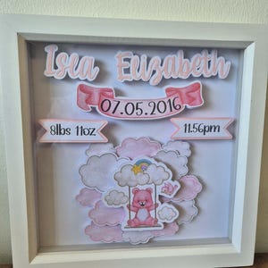 May include: A white framed baby announcement with the name "Isea Elizabeth" in pink script. The announcement includes the date 07.05.2016, weight 8lbs 11oz, and time 11.56pm. A pink bear swings on a cloud with a rainbow.