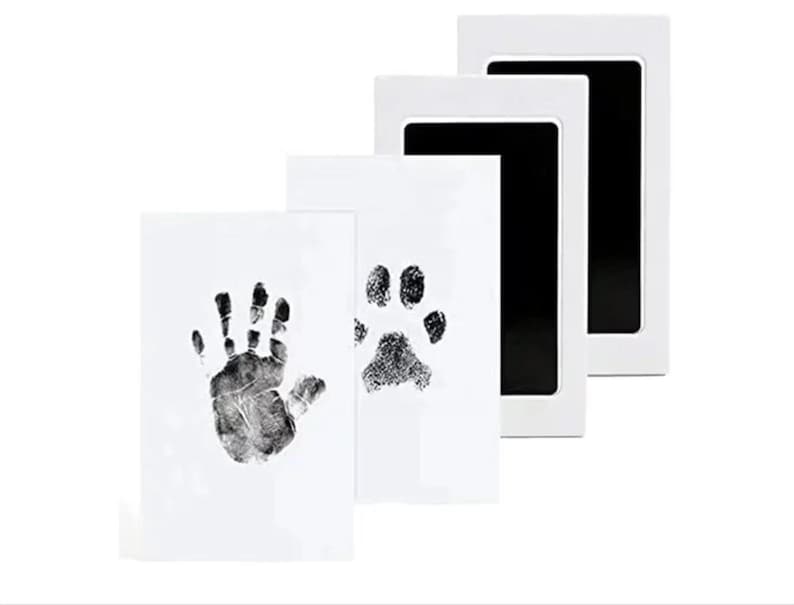 May include: Three white ink pads with black ink wells. The ink pads are for making handprints and paw prints.