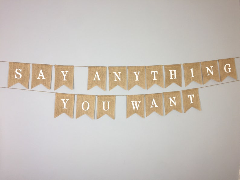 Peut inclure: Une banni&egrave;re en toile de jute avec le texte "SAY ANYTHING YOU WANT" en lettres blanches.