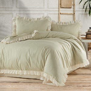 May include: A green and white striped duvet cover with a white ruffle trim. The duvet cover is on a bed with two matching pillowcases.
