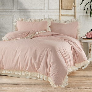 May include: A pink and white striped duvet cover with a ruffled edge. The duvet cover is on a bed with two matching pillowcases.