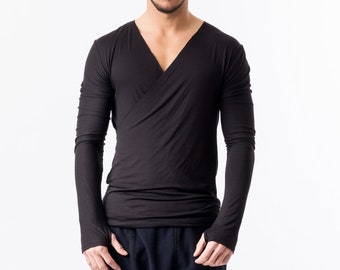 Puede incluir: Una camisa negra de manga larga con cuello en V y un diseño de envoltura. La camisa se combina con pantalones cortos azul oscuro y leggings negros.