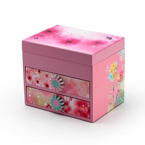 May include: A pink wooden jewelry box with two drawers. The box is decorated with a floral design and has a butterfly on the top. The drawers have floral designs and have a flower-shaped knob.