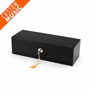 May include: A black wooden box with a lock and key, and a tassel. The box is closed.