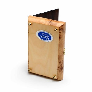 May include: A wooden box with a light brown finish and a blue and white label that reads "Inlaid Wood Cigaro Made in Italy - Sorrento".