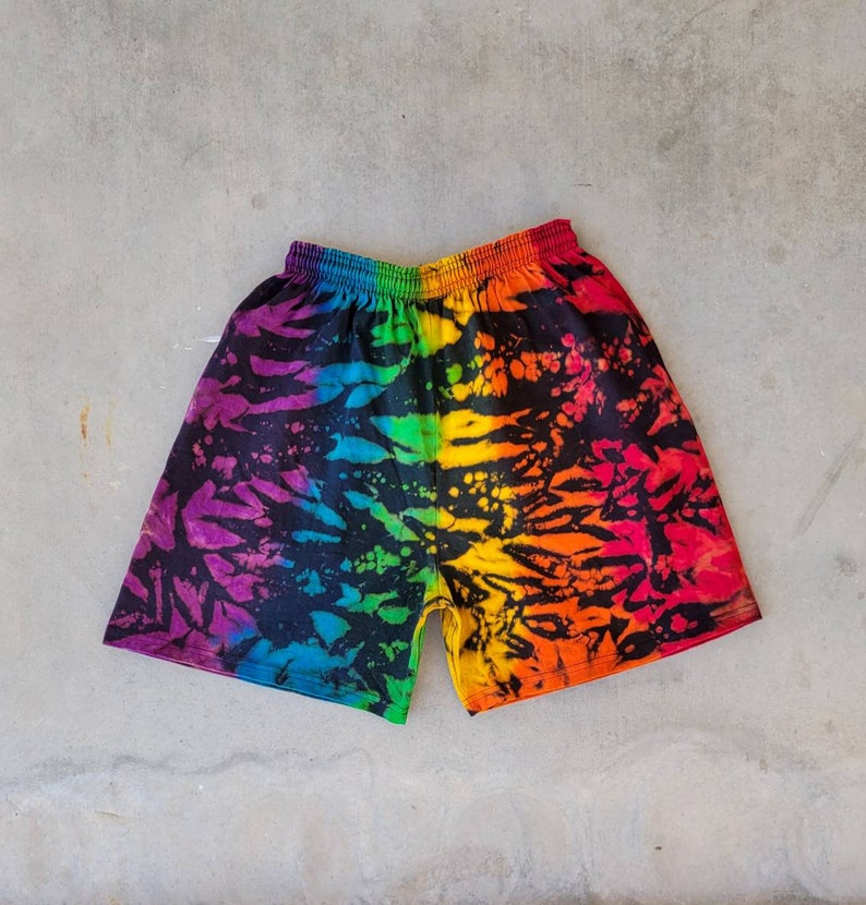 May include: Rainbow tie-dye shorts with a black background and a colorful abstract pattern.