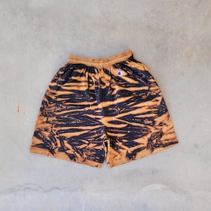 May include: Black and brown tie-dye shorts with a white Champion logo on the left side.