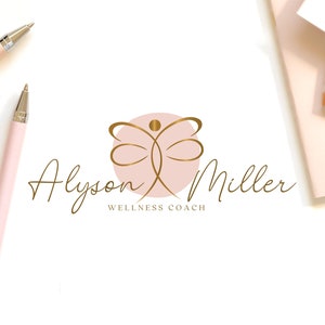 K&ouml;nnte beinhalten: Ein Logo mit einer goldenen abstrakten Figur in einem rosa Kreis, mit dem Namen "Alyson Miller" in goldener Schrift. Unter dem Namen steht der Text "Wellness Coach". Zwei rosa Stifte und ein Notizblock sind ebenfalls sichtbar.