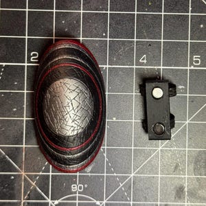 Magnetic attachment for easier connection of the piece to the figure’s arm. The magnets are strong and the shield doesn’t fall off easily