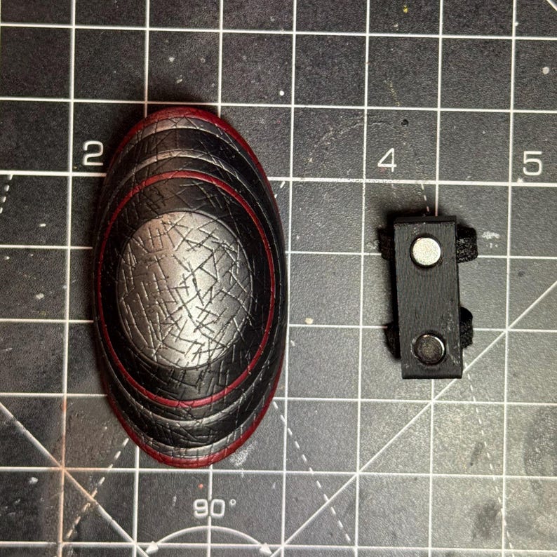 Magnetic attachment for easier connection of the piece to the figure’s arm. The magnets are strong and the shield doesn’t fall off easily