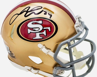 Könnte beinhalten: Ein goldener Mini-Footballhelm mit einem rot-weißen Logo der San Francisco 49ers. Der Helm ist mit "J. Rice 89" signiert.