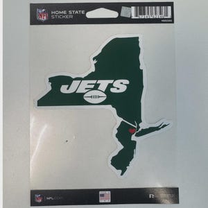 May include: A green New York Jets home state sticker. The sticker is in the shape of New York state with the word "JETS" and a football graphic in white. A red heart marks a location on the sticker.