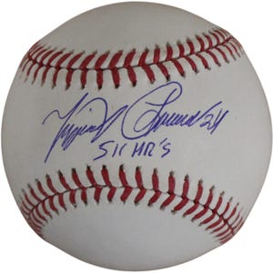 May include: A white baseball with red stitching featuring a blue ink autograph and the handwritten text 51 HR'S. The signature is positioned horizontally across the center of the ball, with the number 24 written next to the signature.