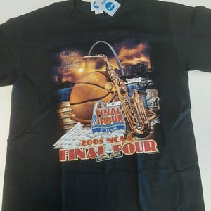 May include: Black t-shirt featuring a basketball, saxophone, and cityscape graphic. The graphic includes the text "2005 NCAA Final Four St. Louis". A white tag with blue text is attached to the shirt.