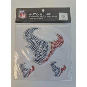 May include: A combo pack of automotive decals featuring the Houston Texans logo, embellished with rhinestones. The decals are in the team's colors of red, blue, and silver. The package includes the NFL logo and the text "AUTO BLING".