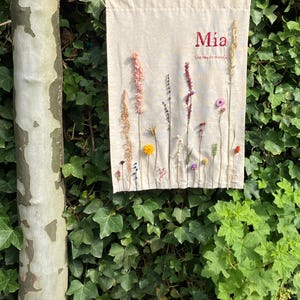 Wall hanging with dried flowers on a linen/cotton/polyester cloth