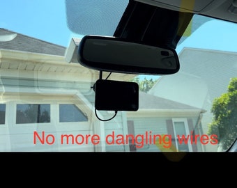 May include: A black dash cam mounted on a car's windshield with a black wire running down the windshield. The text "No more dangling wires" is visible in the image.