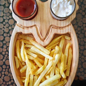 May include: A wooden owl-shaped serving tray with two small bowls for dipping sauces and a larger compartment for french fries. The tray is made of light brown wood and has a natural finish.