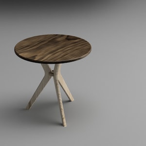 Könnte beinhalten: Ein kleiner runder Holztisch mit einer dunkelbraunen Tischplatte und einem hellen Holzfuß. Der Fuß besteht aus drei Beinen, die in X-Form miteinander verbunden sind.