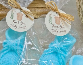 May include: Blue knitted baby booties in clear cellophane bags with a thank you tag that says "Thank You Baby Smith".