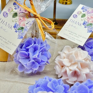 May include: Thank you for showering our baby with love!  A set of small, purple and white hydrangea-shaped soaps in clear cellophane bags with a thank you tag.  Brooklyn's Baby Shower 10.10.2024.