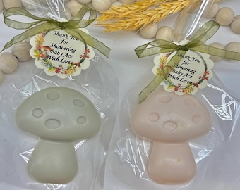 May include: Two mushroom-shaped soaps, one light green and one pink, are packaged in clear cellophane bags. Each is tied with a green ribbon and a tag that reads "Thank You for Showering Baby Ace With Love."