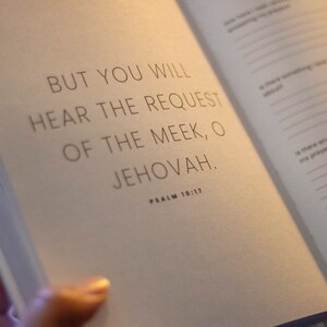 Puede incluir: Un libro abierto con fondo blanco y texto negro. El texto dice "BUT YOU WILL HEAR THE REQUEST OF THE MEEK, O JEHOVAH." y "PSALM 10:17".