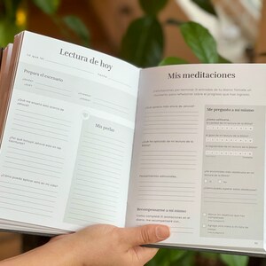 May include: A white and gray journal with the title "Lectura de hoy" and "Mis meditaciones" on the cover. The journal has lined pages for writing and includes prompts for reflection and self-care.
