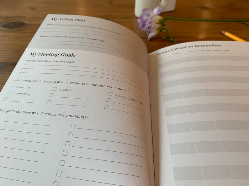 May include: A white planner with a black and gray design. The planner has sections for "My Action Plan", "My Meeting Goals", and "Gems I Want to Remember".