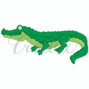 May include: A green alligator with a white eye, embroidered on a white background.