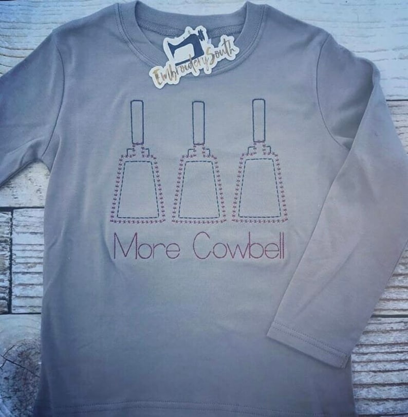 May include: A gray long-sleeve shirt with three cowbells embroidered on the front. The text "More Cowbell" is embroidered below the cowbells.