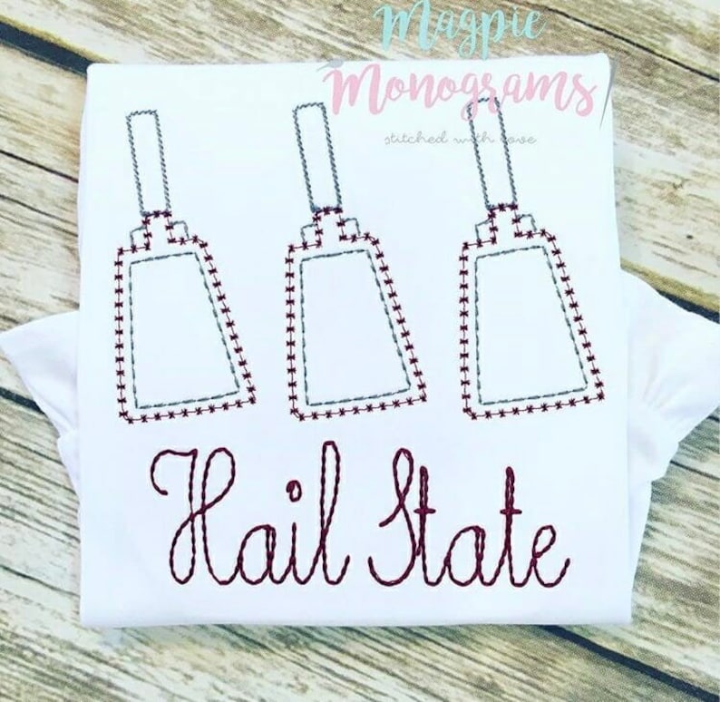 May include: White t-shirt with three maroon cowbells and the text "Hail State" in maroon embroidery.