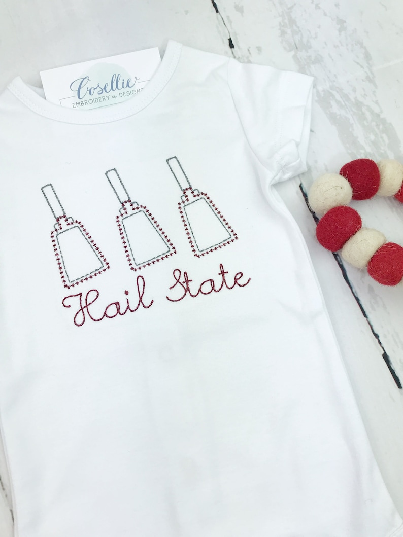 May include: White baby onesie with red embroidered bells and the text "Hail State".