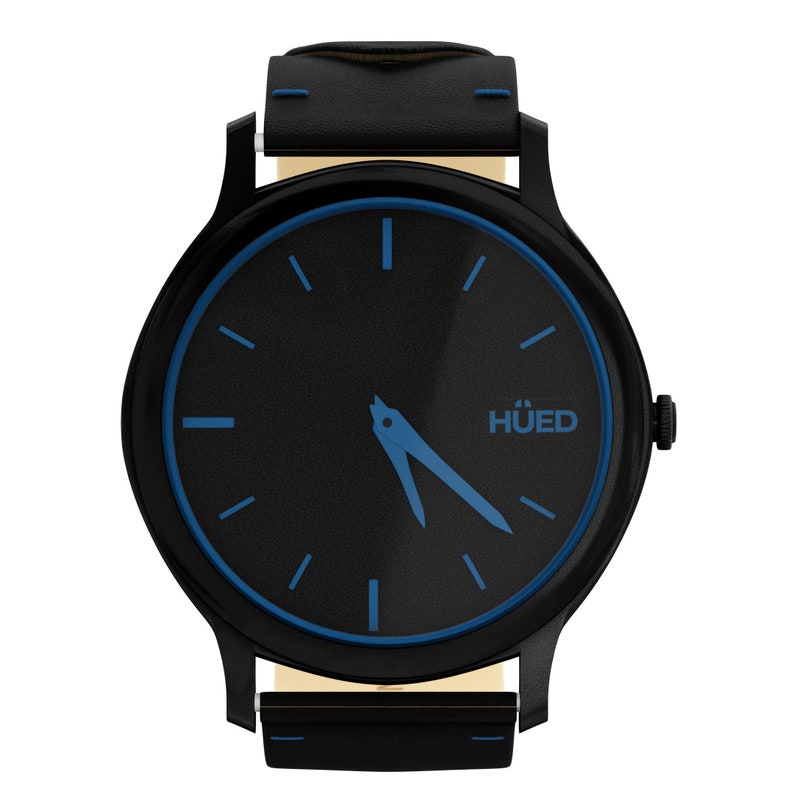 Puede incluir: Un reloj de pulsera negro con una correa de cuero negro y una esfera azul. La esfera del reloj tiene un borde azul y agujas de hora y minuto azules. La esfera del reloj tambi&eacute;n tiene la palabra "HUED" impresa.
