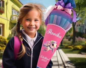 Pode incluir: Um cone escolar rosa e azul com um desenho de tartaruga. O cone tem o nome "Annika" e o texto "Schulkind 2024" impresso nele.