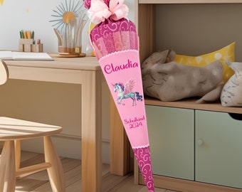 May include: Pink and purple school cone with a unicorn design and the name "Claudia" and the text "Schulkind 2024".