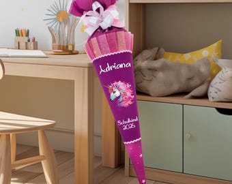 May include: A purple school cone with a unicorn design and the name "Adriana" and the text "Schulkind 2025".