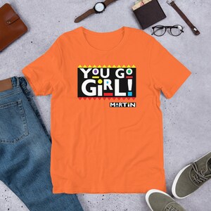 ユーゴーガールTシャツ、ファニーマーティンショーシャツ、90年代シットコムTシャツ、明るい色好き
