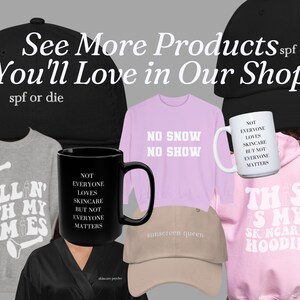 Puede incluir: Colecci&oacute;n de ropa y accesorios con tem&aacute;tica de cuidado de la piel. Incluye gorras de b&eacute;isbol negras y beige, una taza negra, una taza blanca, una sudadera con capucha rosa, una sudadera rosa y una bata negra. Textos: "See More Products You'll Love in Our Shop", "spf or die" y "sunscreen queen".