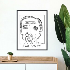 以下が含まれることがあります： アメリカの有名な作家でありジャーナリストであるトム・ウルフの白黒線画。絵は黒い額縁に収められており、絵の下には「TOM WOLFE」という文字が書かれている。