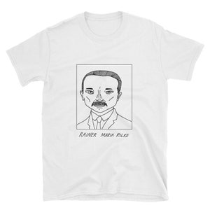 May include: A white t-shirt featuring a black and white line drawing of Rainer Maria Rilke. The drawing is enclosed in a square frame with the text "Rainer Maria Rilke" beneath it.