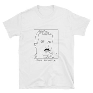 Puede incluir: Una camiseta blanca con un dibujo de línea negra de la cara de John Steinbeck y el texto "JOHN STEINBECK" debajo.